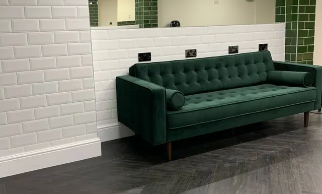 The green velvet sofa in the waiting area at ATMOS